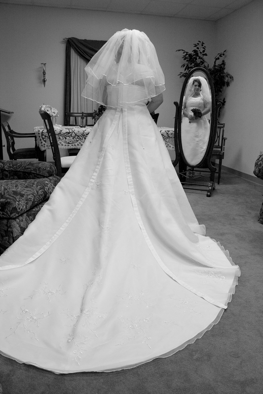 Black and White of bride standing in front of mirror