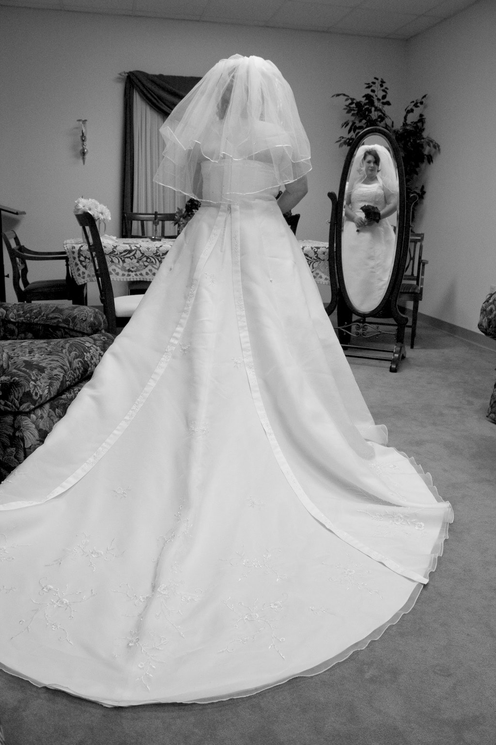 Black and White of Bride standing in front of mirror with reflection