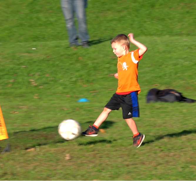 Kid kicking soccer ball