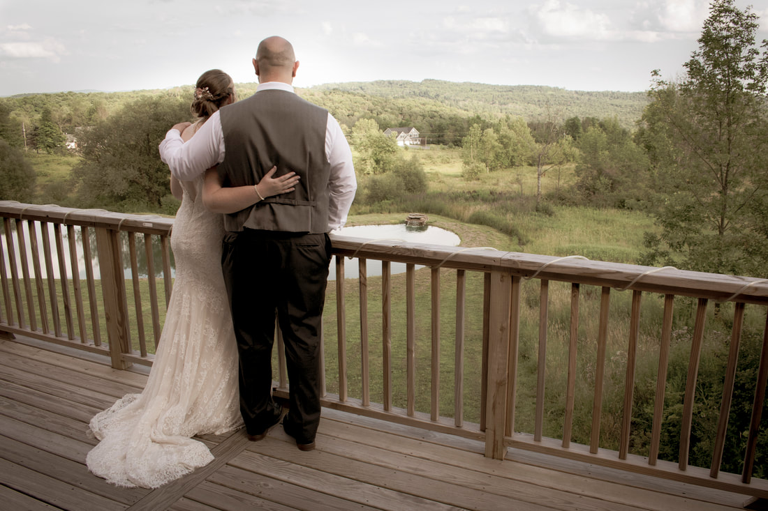 Wedding couple on balcony staring out at the landscape